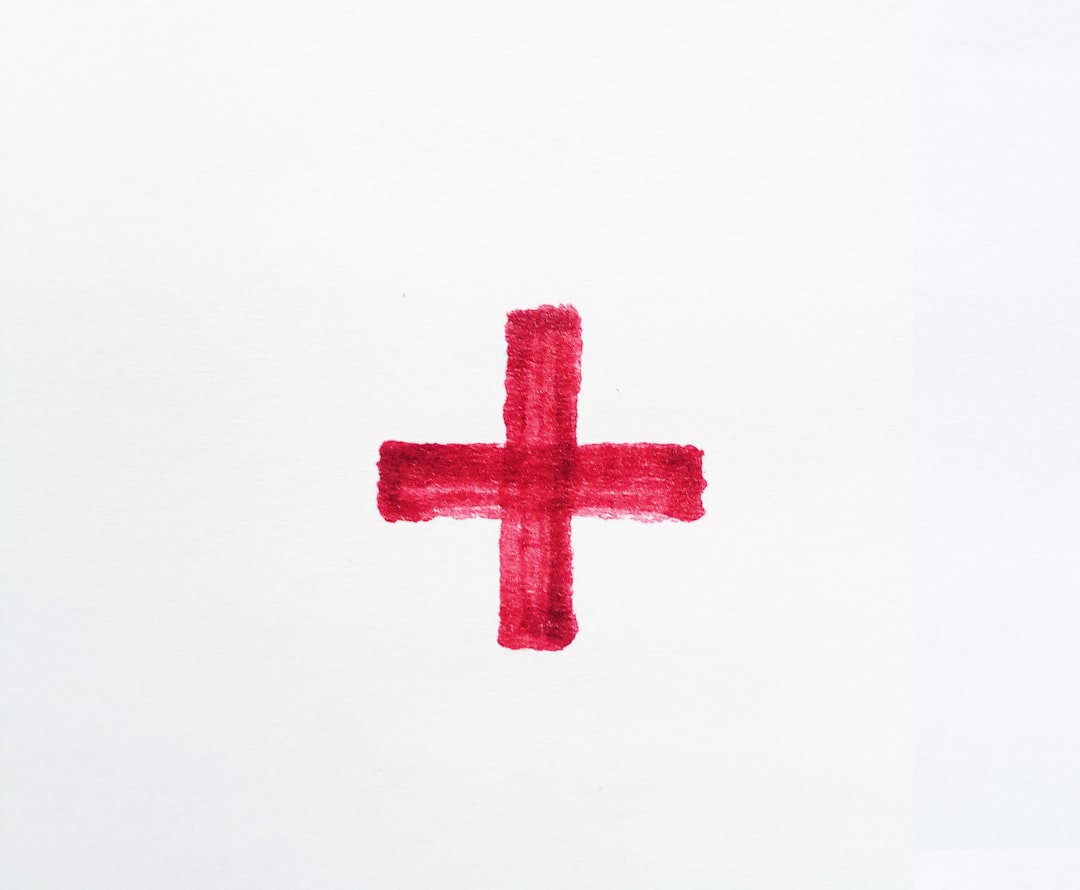 Photo by Ilya Chunin a red cross painted on a white paper